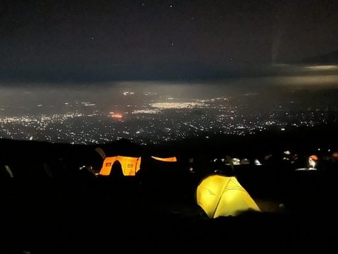 Nachtlager mit leuchtendem Zelt am Berg